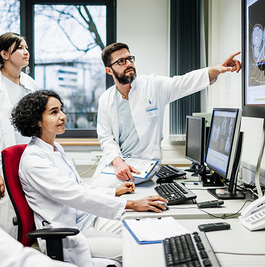 Grupo de médicos analisando exames em computadores